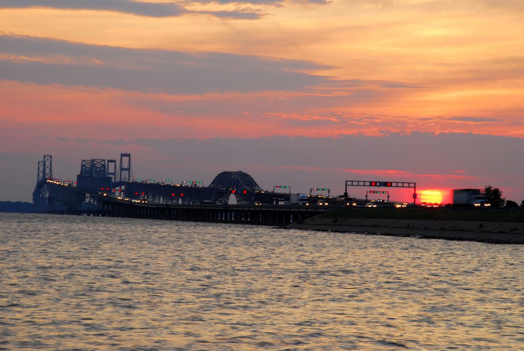 A sunset over the water with a large boat in it.