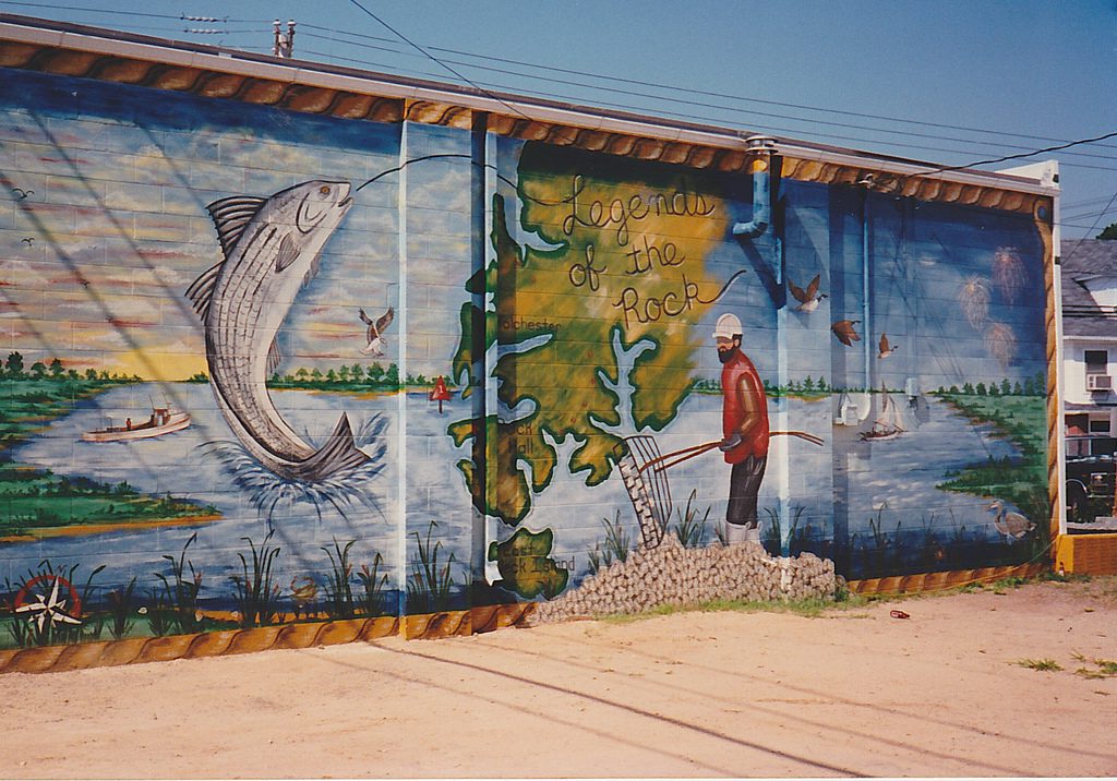 A mural of a man fishing in front of a map.