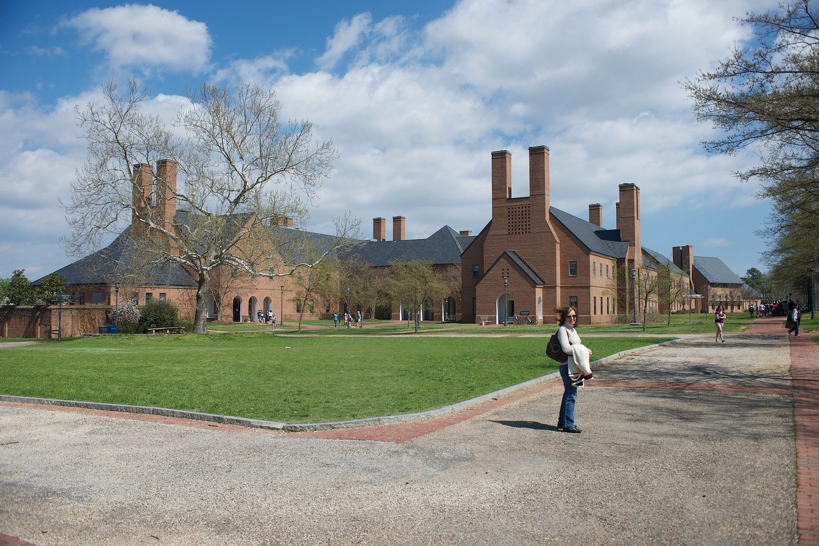 A person walking on the sidewalk near some buildings