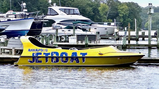 IMG_2981 A yellow boat with blue lettering on the water.