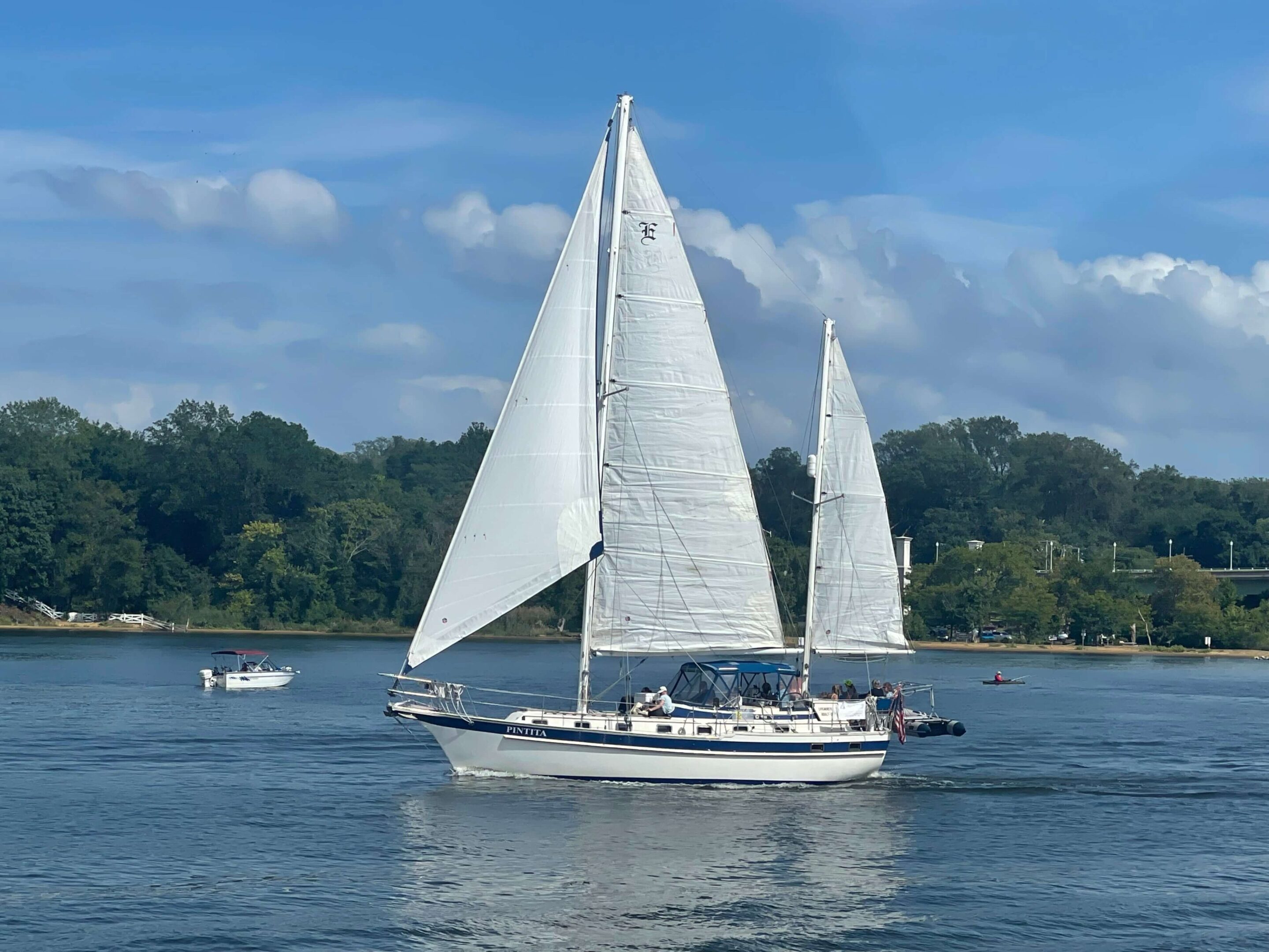 JPEG-image A white sail boat sailing on the water.