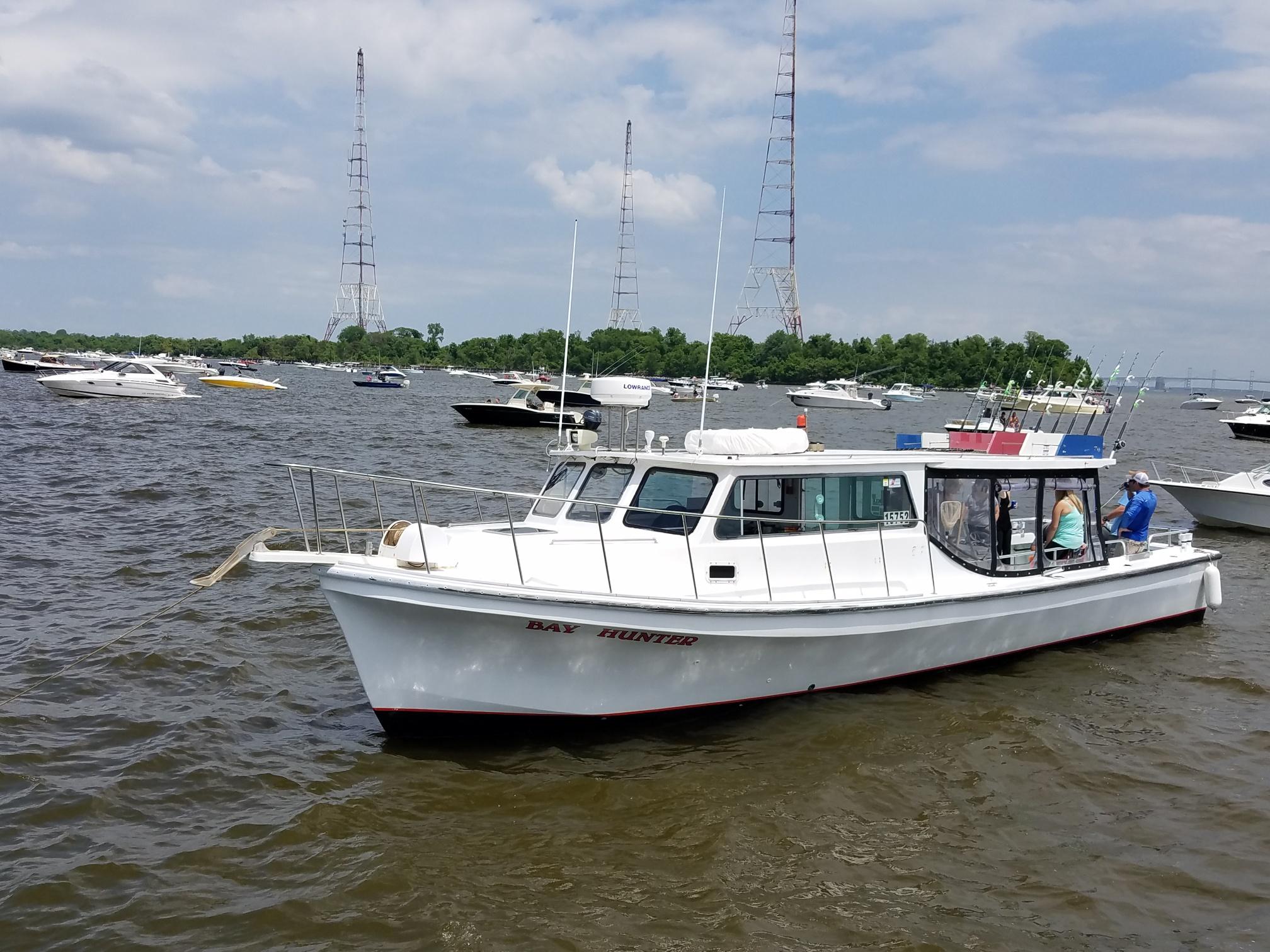 A white boat is in the water near some boats.