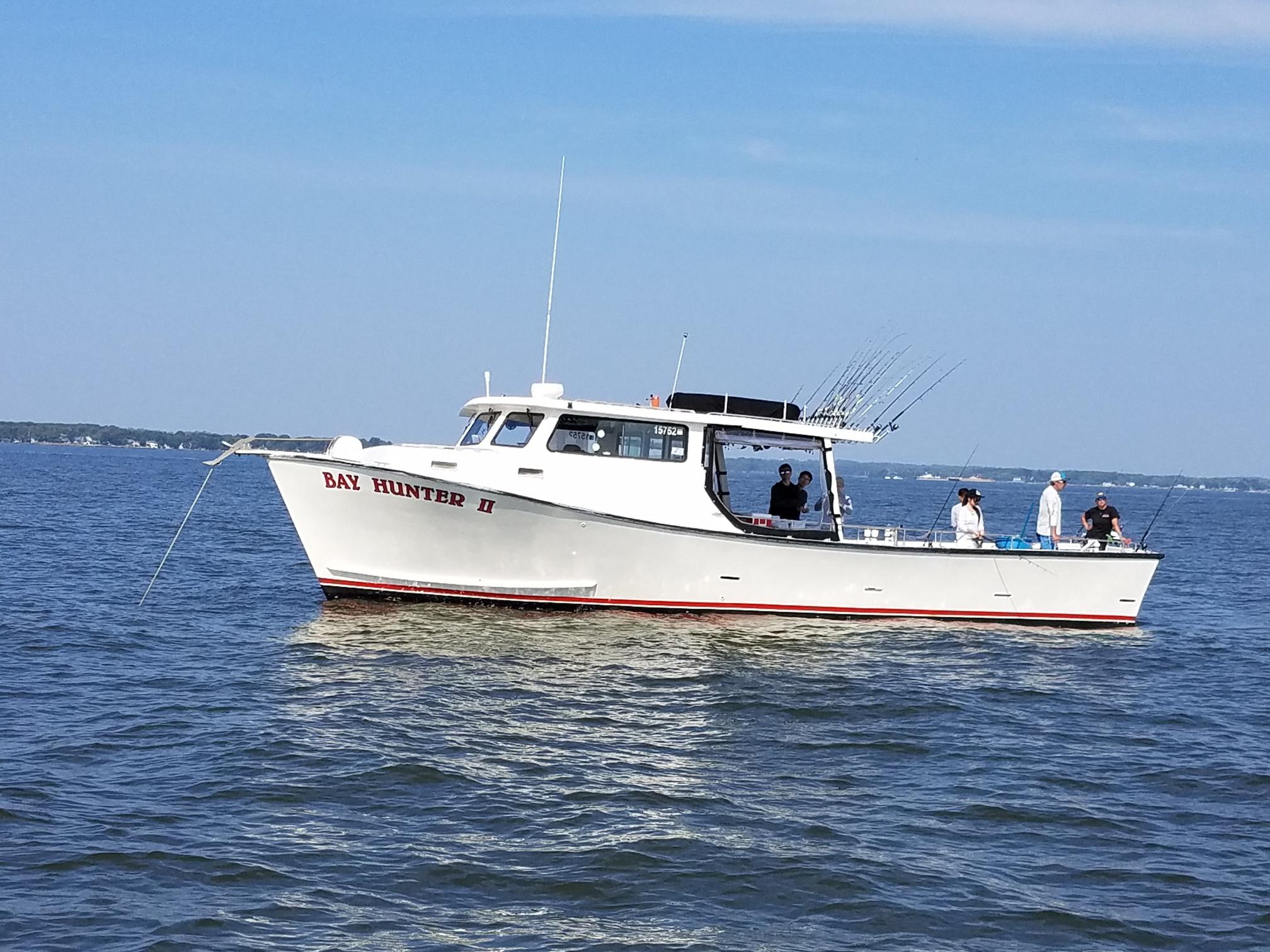 A white boat is in the water and there are other boats
