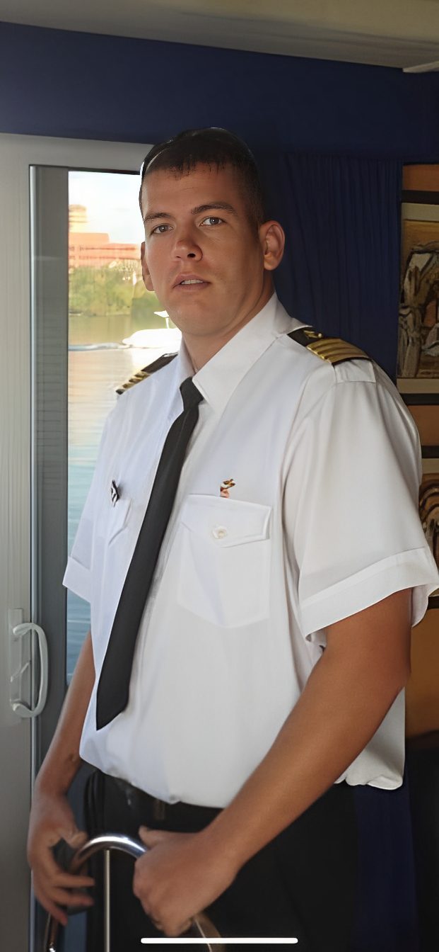 c6227fdf-4ec4-4a83-b76e-ec09497de271 A man in white shirt and tie standing next to window.
