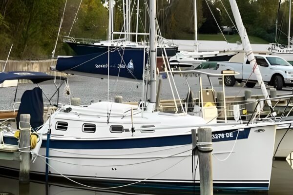 A white boat is docked in the water.