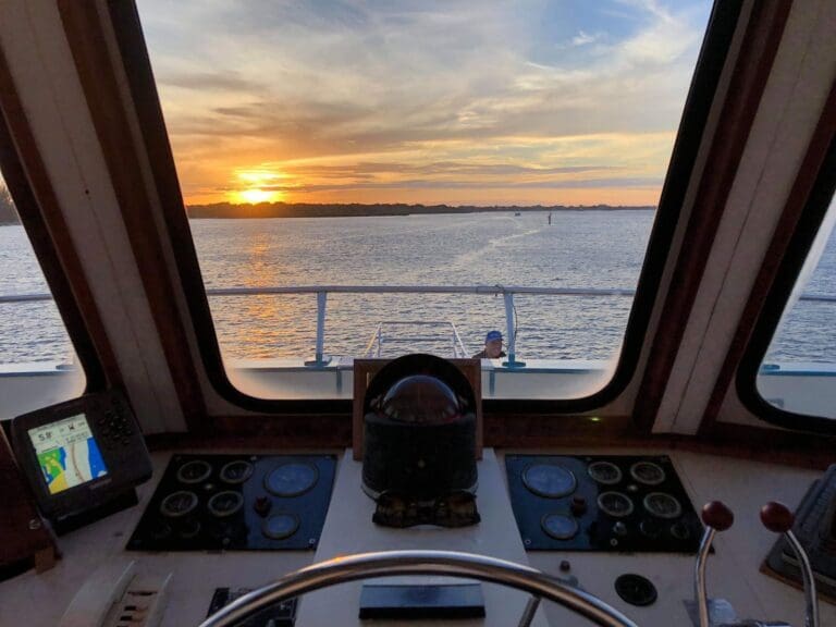 Boat helm overlooking sunset on calm waters